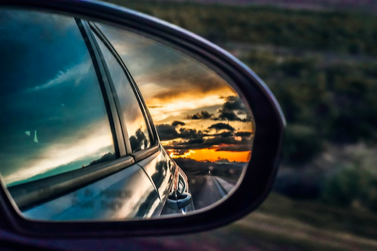 An image of a beautiful sunset viewed in a car side mirror.